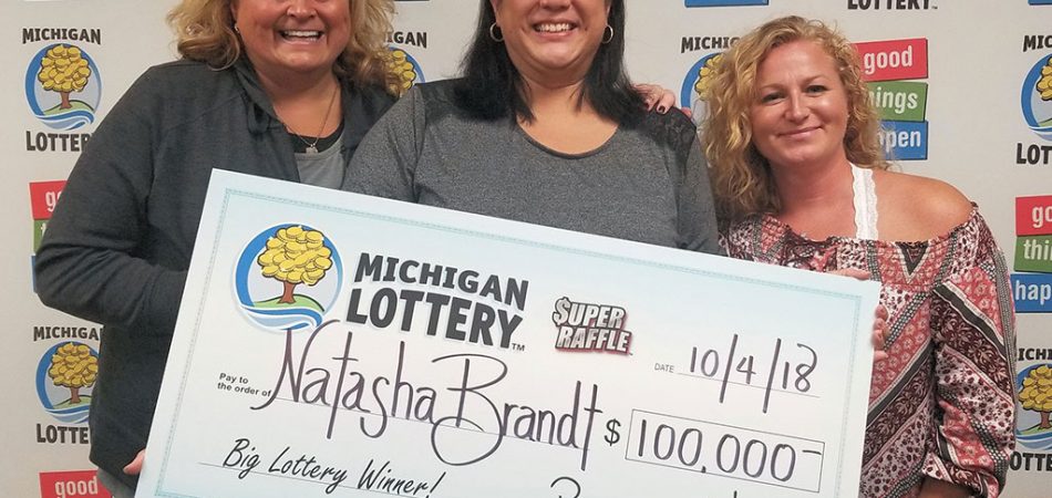 Natasha Brandt (center) smiles after collecting her $100,000 prize with friends Kelley White (left) and Brenna Lantz (right)